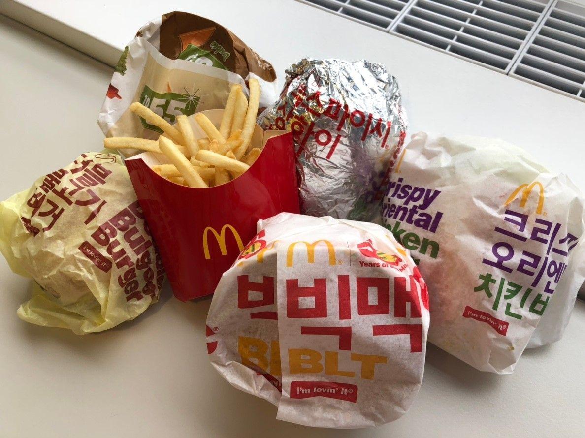 Variety of Korea-exclusive McDonald's burgers and fries wrapped in branded packaging.